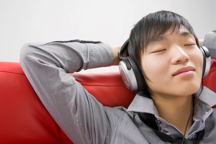 The young man in ear-phones relaxes listening to music